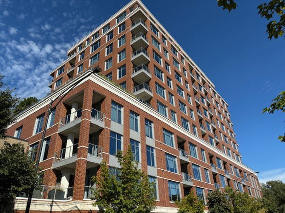 Front view of a multi-story brick building with balconies.