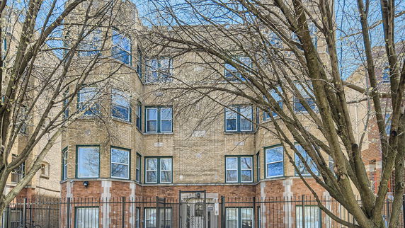 Front view of a multi-story brick building with multiple windows.