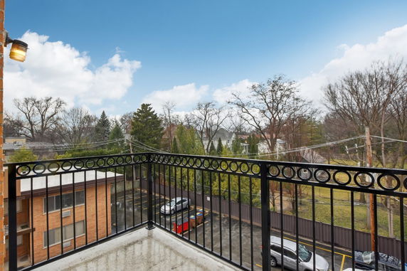 Balcony view overlooking a suburban neighborhood with trees and buildings.