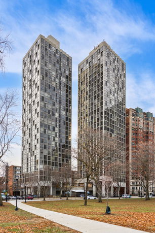 View of two modern high-rise residential buildings with large glass windows.