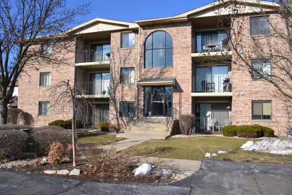 Front view of a multi-story brick apartment building.