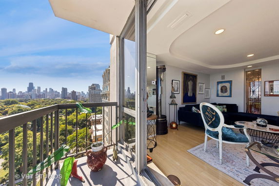 A modern apartment with a balcony offering a panoramic view of a city skyline.