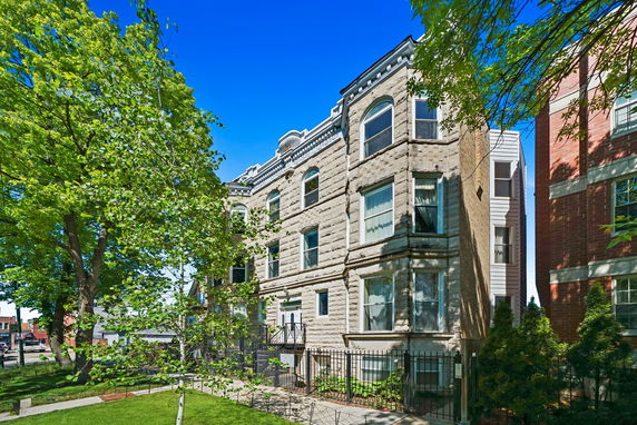 Front view of a stone facade multi-story residential building.
