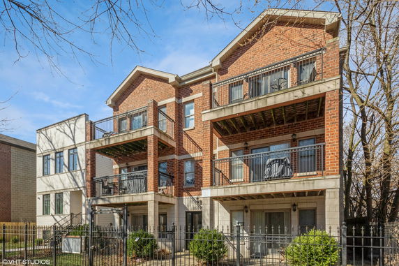 Front view of a multi-story brick building with balconies.