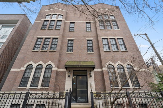 Front view of a three-story brick building with multiple windows and an entrance.