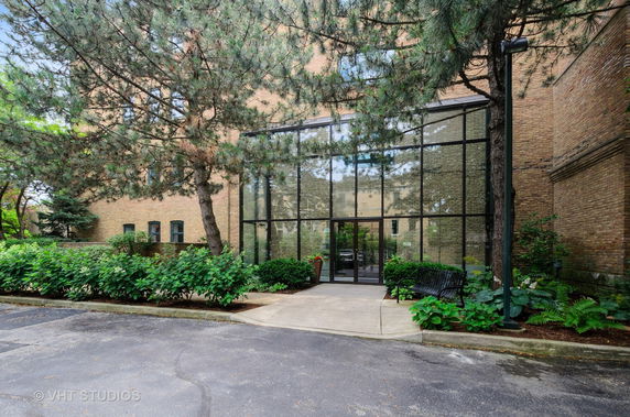 Front view of a building with large glass windows and brick facade.