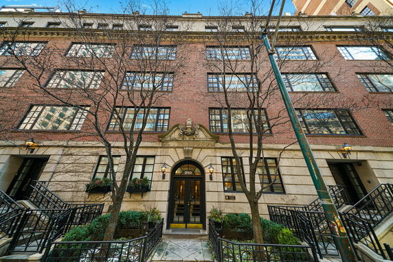 Front view of a multi-story brick building with large windows and an ornamental entrance.
