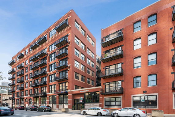Front view of a multi-story brick building with balconies.