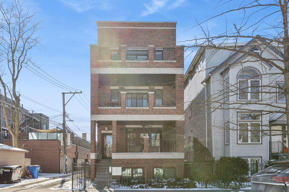 Front view of a multi-story brick building with balconies.