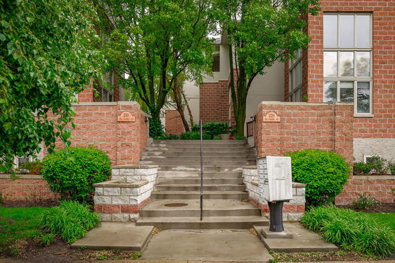 Front view of a brick building with steps leading to the entrance.