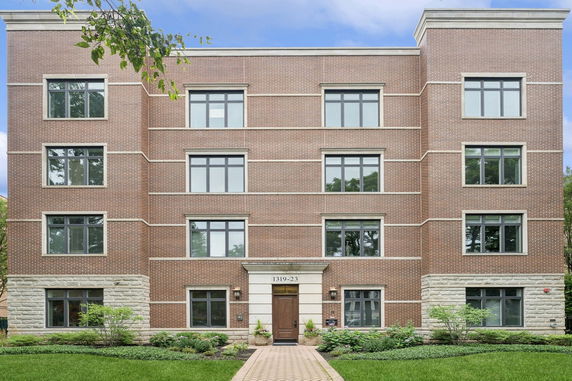 Front view of a four-story brick building with multiple windows.