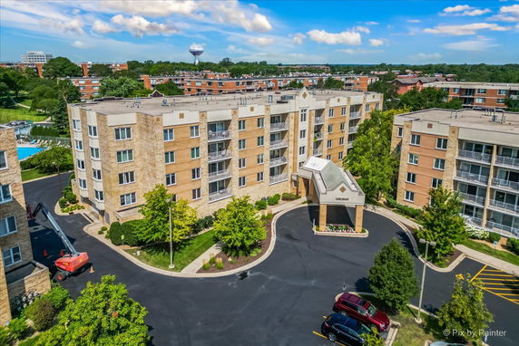 Aerial view of a multi-story apartment building with a covered entrance.