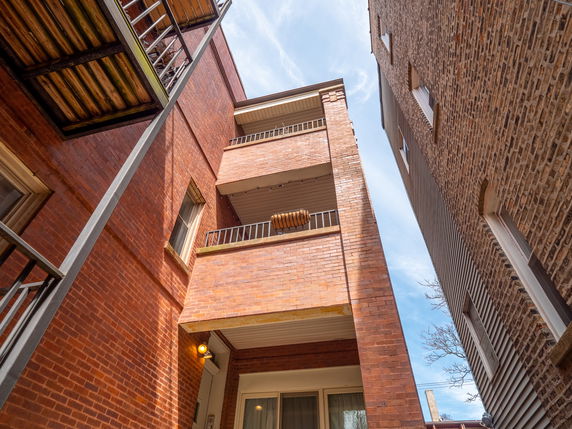View of a multi-story brick building with balconies.