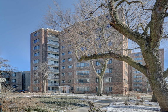Front view of a multi-story apartment building with brick facade.