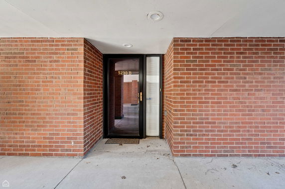 Brick facade with a glass door entrance.