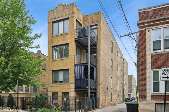 Front view of a multi-story brick building with balconies.