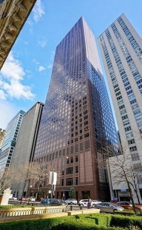 Front view of a tall modern skyscraper with reflective glass facade.
