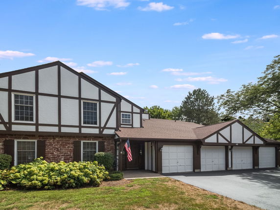 Front view of a house with Tudor-style architecture and a three-car garage.