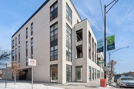 Front view of a modern multi-story building with large windows.
