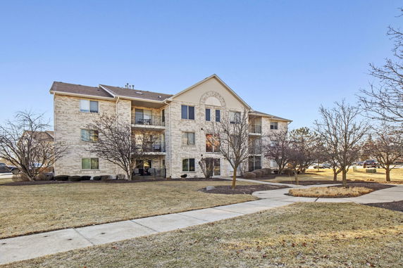 Front view of a three-story apartment building with balconies.