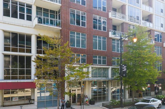Front view of a multi-story building with large windows and a brick facade.