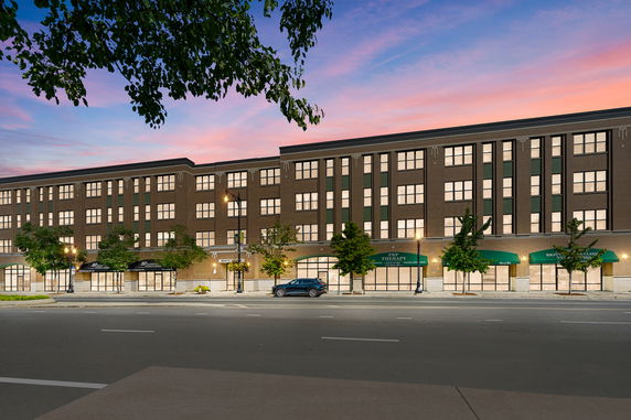 Front view of a multi-story building with storefronts and large windows.