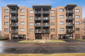 Front view of a multi-story brick apartment building with balconies.
