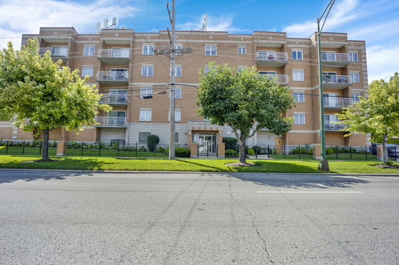 Front view of a multi-story apartment building with balconies.