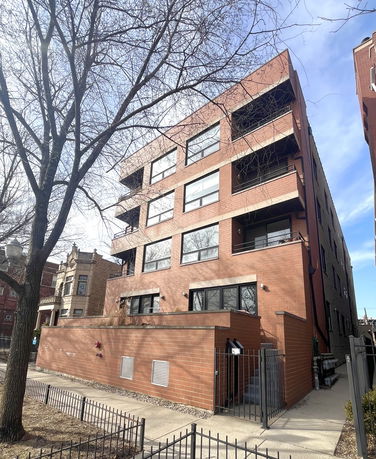 Front view of a multi-story brick apartment building.