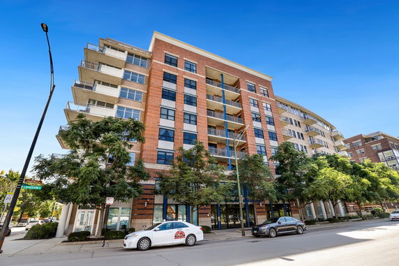 Front view of a multi-story residential building with balconies.