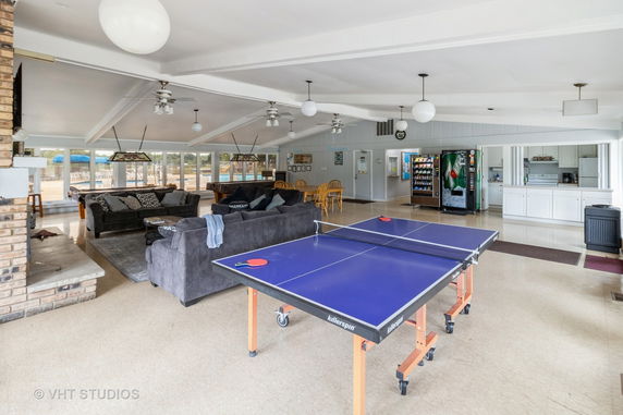 Indoor recreation room with a ping pong table and seating area.