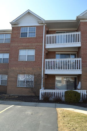 Front view of a multi-story brick building with balconies.