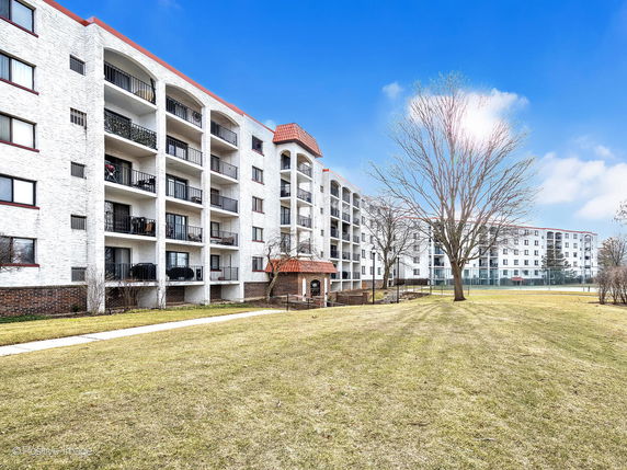 Front view of a multi-story apartment building with multiple balconies.