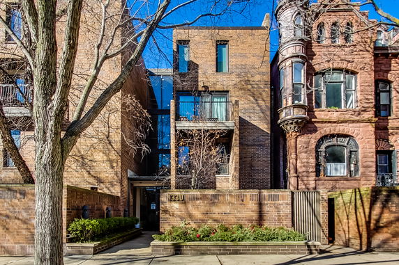 Front view of a multi-story brick building with balconies.