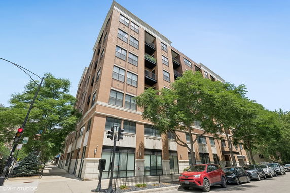 Front view of a multi-story brick building with large windows and balconies.