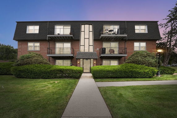 Front view of a multi-story brick building with balconies.