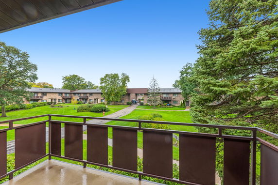 View from a balcony overlooking residential buildings and green lawns.