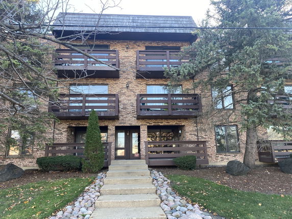 Front view of a multi-story brick building with balconies.