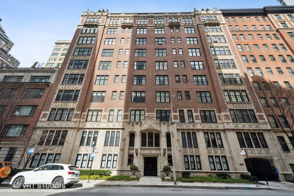 Front view of a multi-story brick building with decorative stonework.