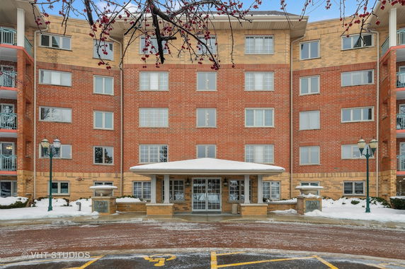 Front view of a multi-story brick building with an entrance canopy.