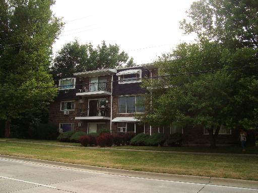 Front view of a three-story apartment building with balconies.