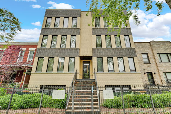 Front view of a multi-story building with numerous windows and a central entrance.