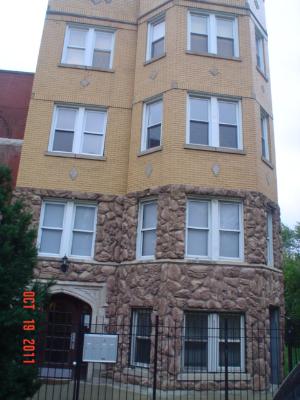 Front view of a multi-story building with a stone facade on the lower level and brick on the upper levels.