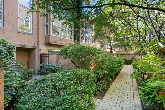 Front view of a multi-story brick building with large windows and a small garden path.