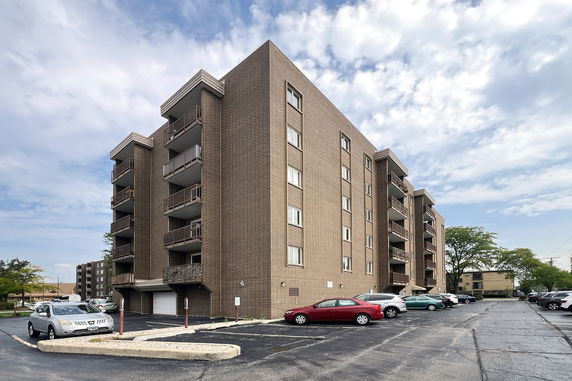 Front view of a multi-story brick building with several balconies.