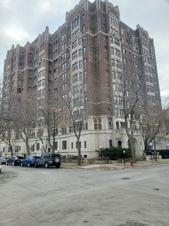 Front view of a multi-story brick building with decorative elements.