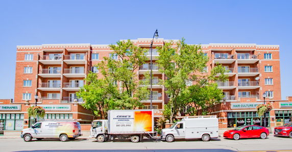Front view of a multi-story brick building with balconies.