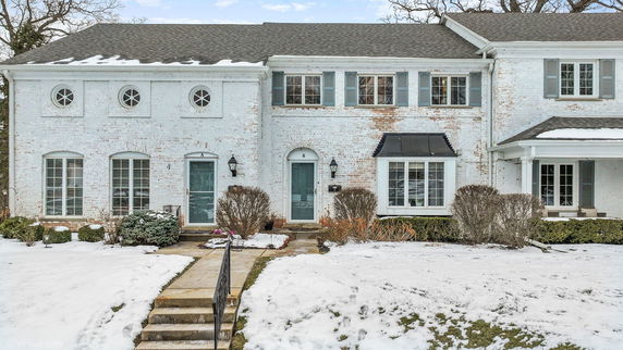Front view of a two-story brick house with blue shutters and doors.