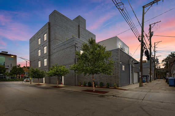 Front view of a modern multi-story building with a brick facade.