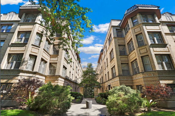 Front view of a multi-story residential building with a courtyard.